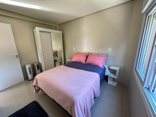 a bedroom with a bed with a pink and blue blanket at Apto excelente in Canela