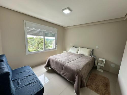 a bedroom with a bed and a window at Apto excelente in Canela