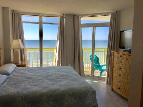 a bedroom with a bed and a balcony with the ocean at Gorgeous Oceanfront 3 Bedrooms Condo Sleeps up to10 people - Initial supply of Linens Included in Myrtle Beach