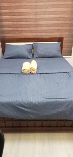 a bed with two towels and two pillows on it at Mi Casa Nova in Bacolod