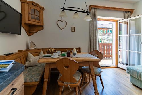 a dining room with a wooden table and chairs at Gästehaus Hinterponholz in Ramsau