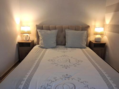 - une chambre avec un lit et deux lampes de chaque côté dans l'établissement Port Azur GOLFE JUAN, à Vallauris