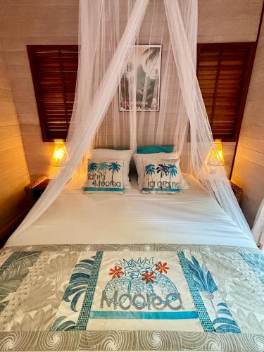 a bed in a room with a mosquito net at Le Fare Tianee, Résidence Légends, BEST VIEW in Moorea