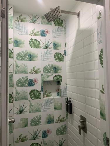 a bathroom with a shower with green plants on the wall at Kasa Boutique Hotel in Cebu City