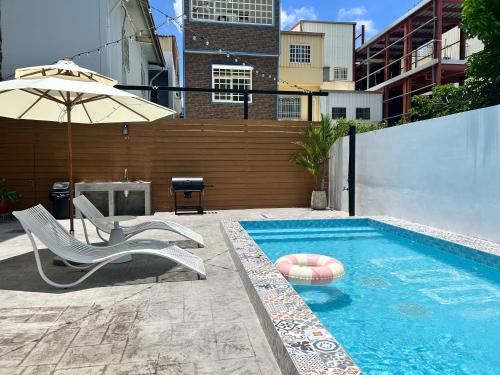 una piscina con sedia e ombrellone di 墾丁恆春包棟 l 洛夫特Looft民宿 a Città Vecchia di Hengchun
