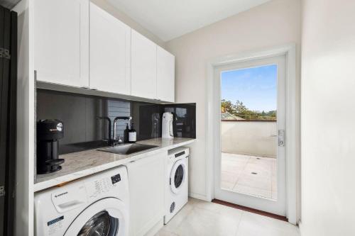 a kitchen with a washer and dryer in a room at Urunga Magic 1A in Urunga