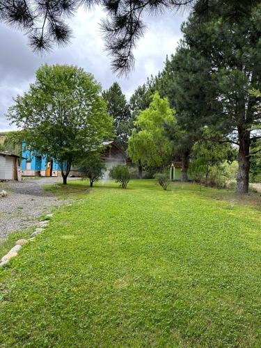 a yard with green grass and trees at Aromas de Montaña II in Junín de los Andes