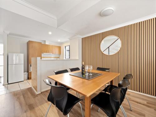 a dining room with a wooden table and black chairs at Margs Central Stay in Margaret River Town