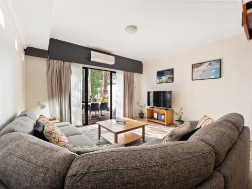 a living room with a couch and a tv at Margs Central Stay in Margaret River Town
