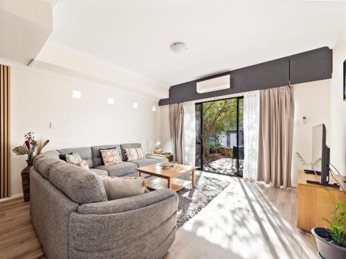 a living room with a couch and a tv at Margs Central Stay in Margaret River Town