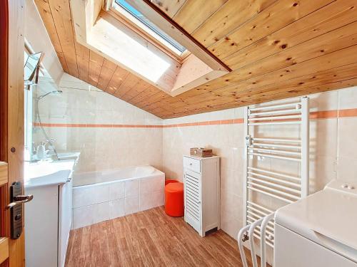 a bathroom with a bath tub and a sink and a skylight at Appartement 6 pers à La Clusaz, balcon et wifi - FR-1-818-103 in La Clusaz
