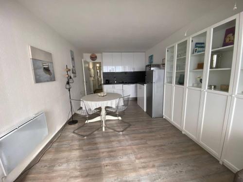 une petite cuisine avec une table et un réfrigérateur dans l'établissement T2 4 pers à Le Barcarès, face mer, parking privé - FR-1-81-640, au Barcarès