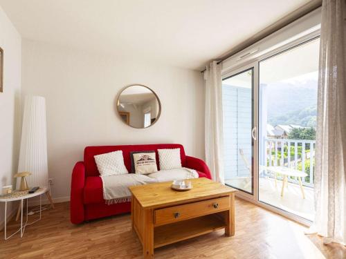 un salon avec un canapé rouge et une table dans l'établissement Appartement rénové à Vielle-Aure, 4 pers, parking - FR-1-296-520, à Vielle-Aure