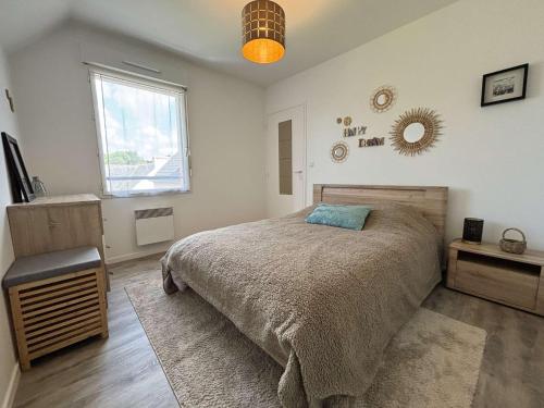 a bedroom with a large bed and a window at Appartement cosy pour 4 personnes au cœur de la Forêt-Fouesnant - FR-1-481-179 in La Forêt-Fouesnant