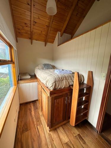 a small bedroom with a bed in a tiny house at Aromas de Montaña II in Junín de los Andes