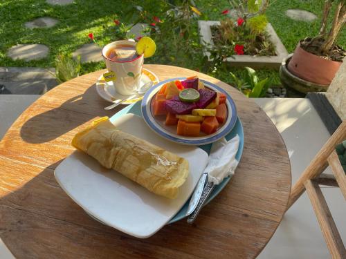 un piatto di cibo con un burrito e una ciotola di frutta di Mada Homestay a Bedahulu