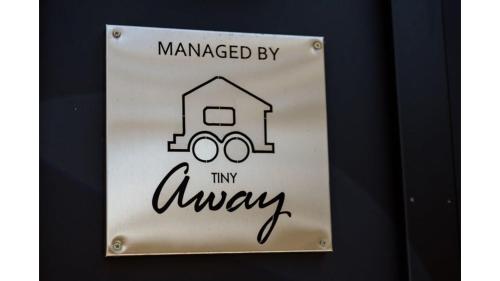 a sign on a wall with the words managed by my always at Sunset Vine at Wonganella Estate 1 by Tiny Away in Bobs Farm