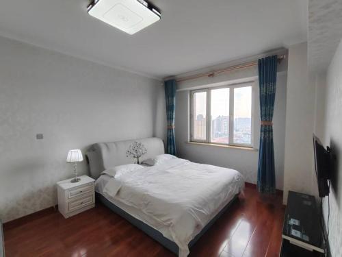 ハルビン市にあるCentral Street Apartmentのベッドと窓のある小さな寝室