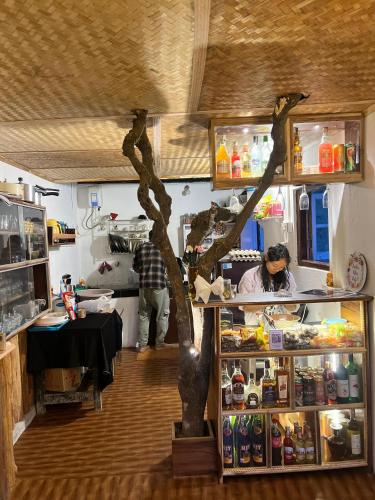 a shop with a tree in the middle of a room at The Blue House in Pelling