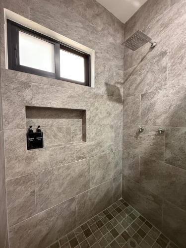 a bathroom with a walk in shower and a window at Departamento Colima 2 in Colima