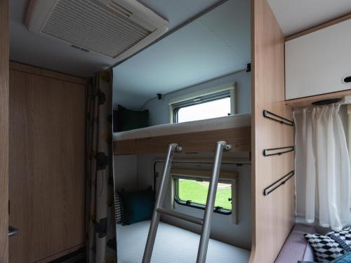 a small room with a bunk bed and a window at Aquaignis Awaji Island TRAILER PARK in Awaji