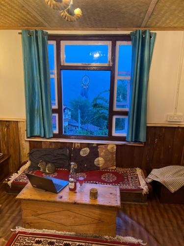 a room with a window and a table with a laptop at The Blue House in Pelling