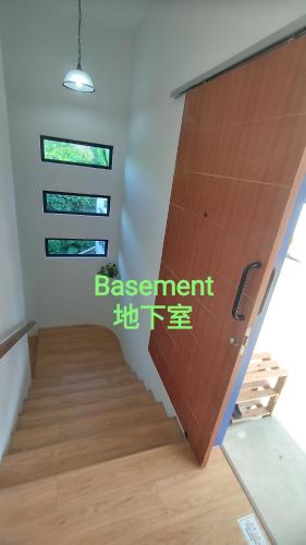 a staircase in a room with a wooden door at Sunya Home Raub Pahang Basement in Raub