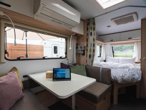 a small room with a table and a bed in it at Aquaignis Awaji Island TRAILER PARK in Awaji