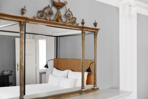 a mirror over a bed with white pillows at Hotel Astoria Vienna, Curio Collection by Hilton in Vienna