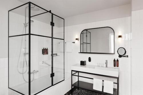 a bathroom with a glass shower and a sink at Hotel Astoria Vienna, Curio Collection by Hilton in Vienna