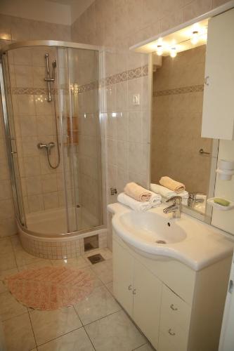 a white bathroom with a shower and a sink at Apartments Vila&Zora in Vodice