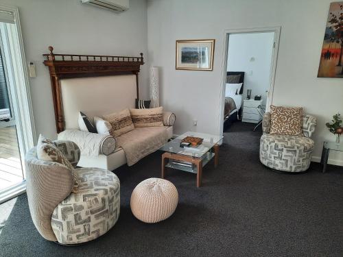 a living room with two chairs and a couch at Villa One on Fitzherbert in Palmerston North