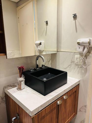a bathroom with a black sink and a mirror at Morada Premium MCR Pinheiros in Sao Paulo