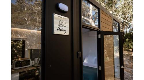 a door with a sign on the side of it at Sunset Vine at Wonganella Estate 2 by Tiny Away in Bobs Farm