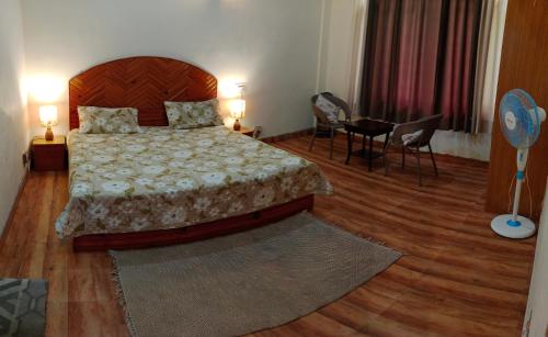 a bedroom with a bed and a table and chairs at Quaint stays - By the river beas in Haripūr