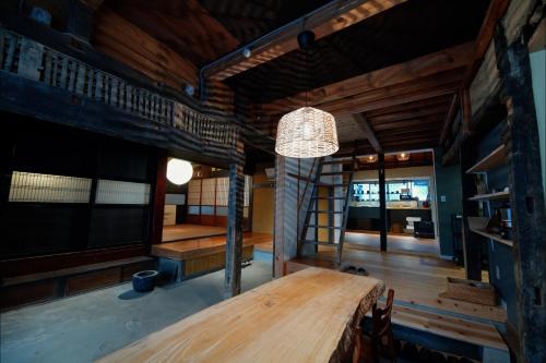 朝来市一棟貸宿市御堂的一间带木桌和吊灯的用餐室