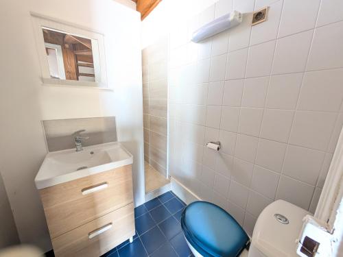 une salle de bain avec des toilettes bleues et un lavabo dans l'établissement T3 duplex 50m², 2 chambres, proche plage, 6 pers - FR-1-797-1, à Port-la-Nouvelle