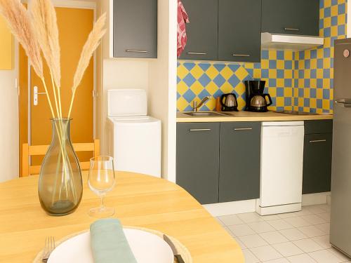 une cuisine avec une table en bois et un vase en verre dans l'établissement Pavillon climatisé 2** à 10 min de la plage - 2 chambres, cuisine équipée, parking sécurisé - FR-1-732-47, à Argelès-sur-Mer