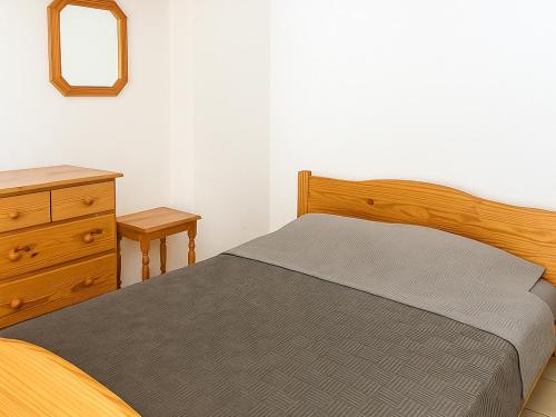 une chambre avec un lit, une commode et un miroir dans l'établissement Pavillon climatisé 2** à 10 min de la plage - 2 chambres, cuisine équipée, parking sécurisé - FR-1-732-47, à Argelès-sur-Mer