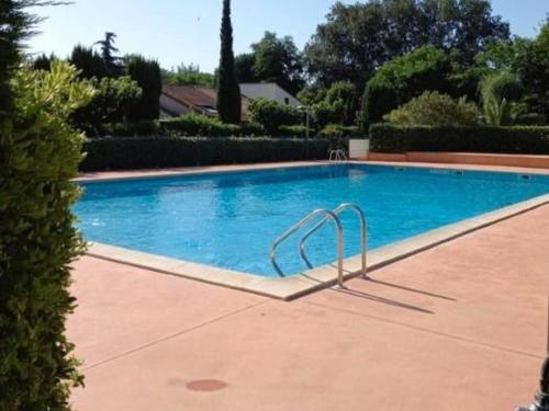 une piscine avec de l'eau bleue dans une cour dans l'établissement Charmant Pavillon à Argelès-sur-Mer avec Piscine, Terrasse et Parking - FR-1-732-23, à Argelès-sur-Mer