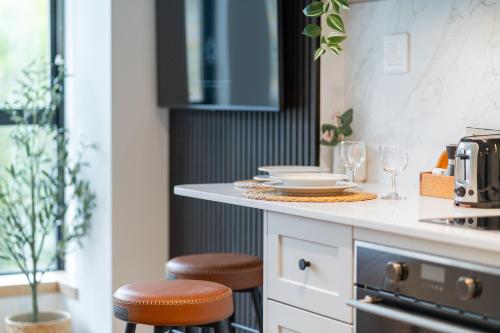 a kitchen with stools and a counter with dishes on it at The Summit Room Whistler Village in Whistler