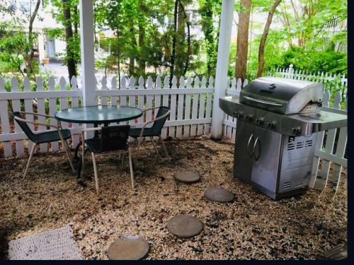 a grill and a table and chairs on a patio at Perfect Family Vacation at Bethany Beach Cottages! in Bethany Beach