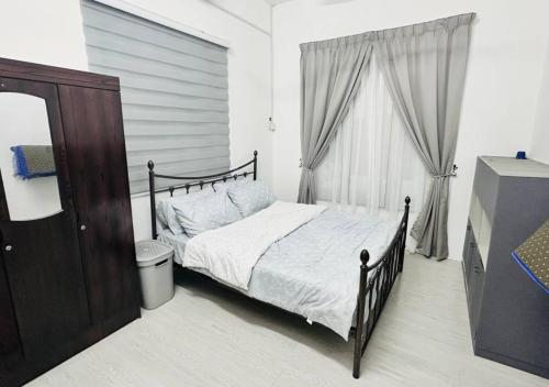 a bedroom with a bed and a dresser and a television at DVillage Homestay Kelantan Kota Bharu Free Wifi Bilik Aircond in Kota Bharu