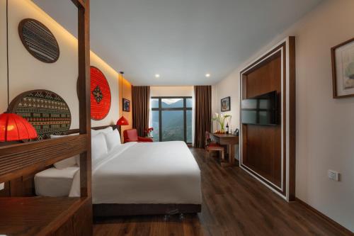 a hotel room with a bed and a television at Lestar Hotel Sapa in Sa Pa