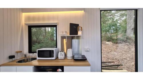 a kitchen with a counter with a microwave and a window at Sunset Vine at Wonganella Estate 2 by Tiny Away in Bobs Farm