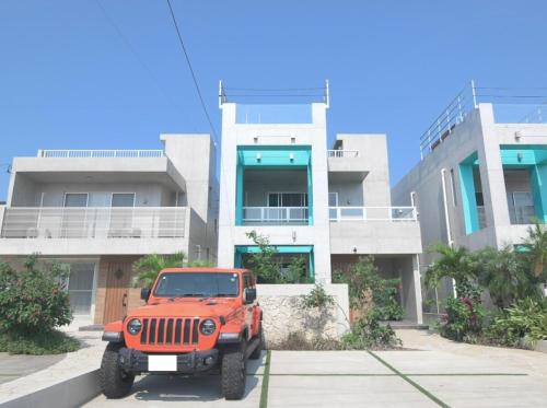 a red jeep parked in front of a building at at60percent in Miyako-jima