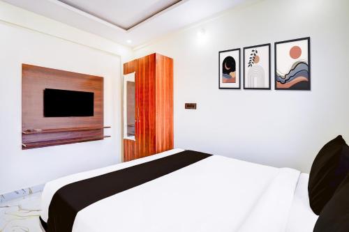 a bedroom with a bed and a flat screen tv at Super Collection O ITPL Bangalore in Bengaluru