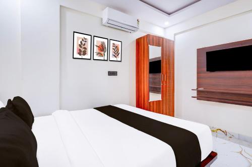 a white bedroom with a bed and a flat screen tv at Super Collection O ITPL Bangalore in Bengaluru
