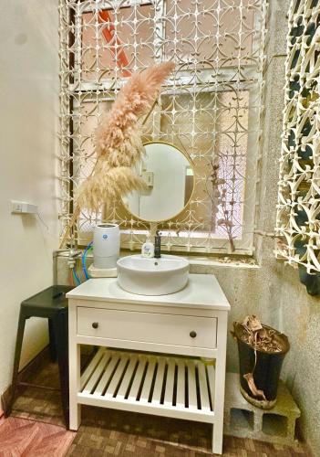 a bathroom with a white sink and a mirror at Liu Xu Homestay in Tainan