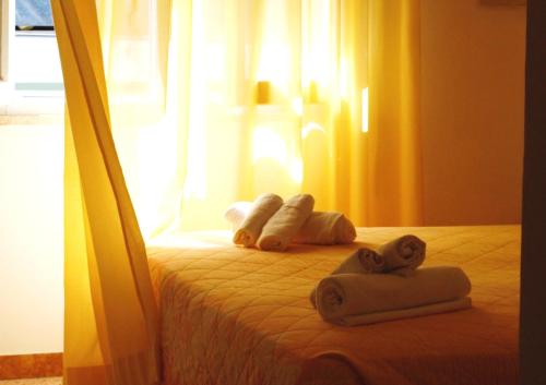 a bedroom with a bed with towels on it at Hotel Lux in Cesenatico